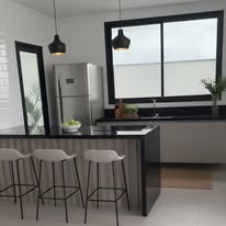 Cozinha integrada com ilha, banquetas e luminárias pretas